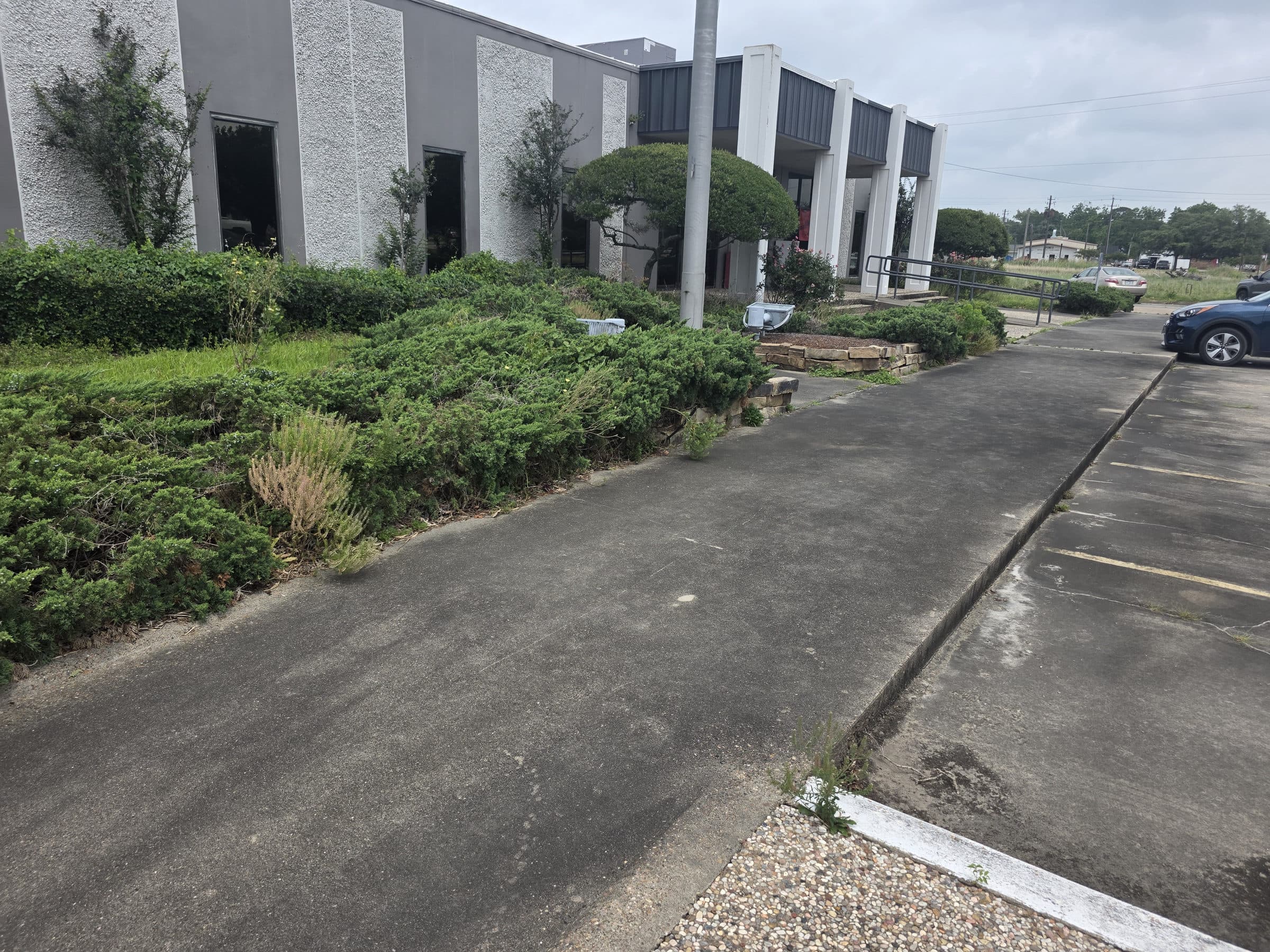 A commercial property exterior being cleaned, with the walkway and entry area washed down